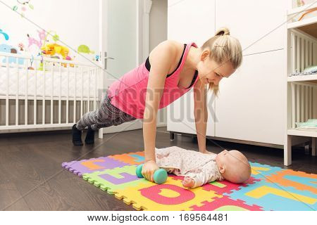 mother doing fitness and playing with her baby