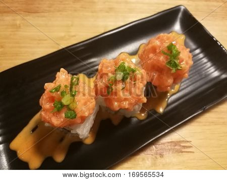 Fusion salmon sushi stuff with cucumber crab stick and mango Stylist food medium shot