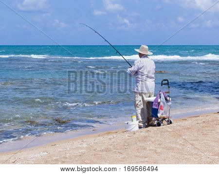 Elderly Man Fishing With A Fishing Rod