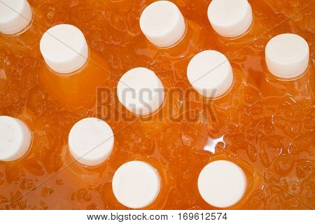chilled bottle of orange juice on ice box.