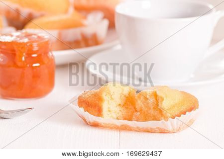 Breakfast with plumcake and apricot jam on white dish.