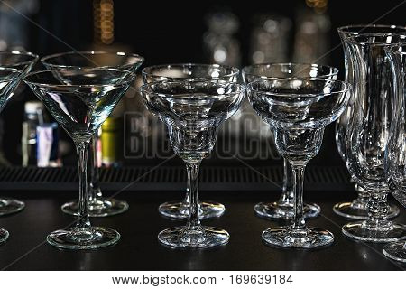 Glasses For A Margarita, Martini, Grog And Liqueur On A Bar At Restaurant, Against The Bar Bar Wall