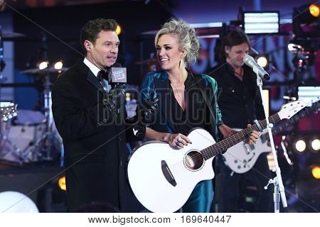 NEW YORK-DEC 31: Host Ryan Seacrest (L) and recording artist Carrie Underwood onstage during Dick Clark's New Year's Rockin' Eve at Times Square on December 31, 2015 in New York City.