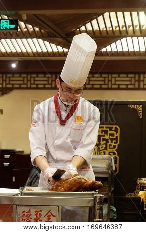 BEIJING - FEBRUARY 22: Cutting peking duck on a plate in the original Quanjude restaurant at the Qianmen street in Beijing, China, February 22, 2016.