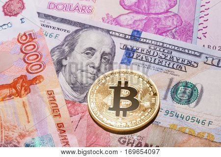 One Bitcoin on multicurrency banknotes. Closeup, Macro shot