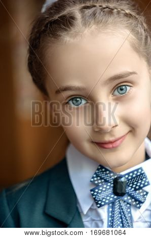 Little student girl writing in notebook at school. Closeup portrait of schoolgirl. First day in school.