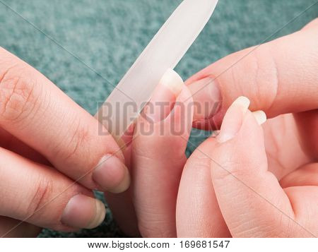 Woman using nailfile during making menicure herself