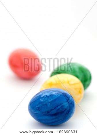 Four colored Easter eggs: blue, red, yellow and green.