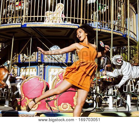 teenage with candy near carousels in park