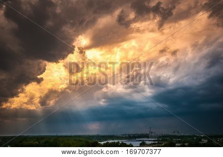 Nuclear power plant with an beautiful dramatic stormy evening sky with artistic clouds and sunbeams. Environmental wallpaper. Industrial background.
