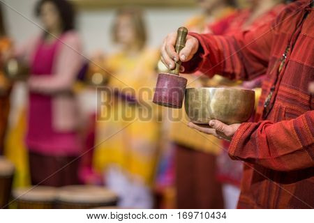 Man playing on a tibetian singing bowl (shallow DOF; color toned image)