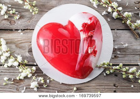 Red heart cacke desserts and sakura on wooden background. dessert for breakfast on Valentine's Day.
