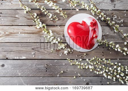Red heart cacke desserts and sakura on wooden background. dessert for breakfast on Valentine's Day.