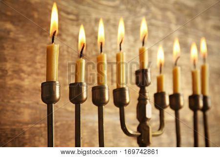 Menorah with candles for Hanukkah on wooden background, close up