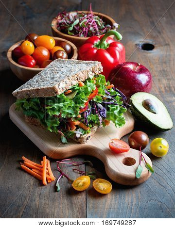 Vegan wholegrain sandwich with ingredients for healthy meal avocado micro greens super food diet concept selective focus toned image