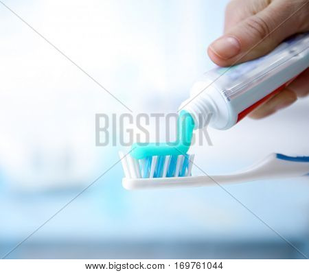 Toothbrush and toothpaste on blurred background