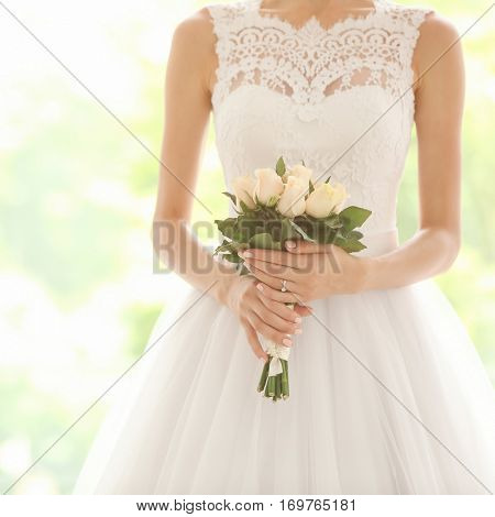 Bride in beautiful dress holding wedding bouquet
