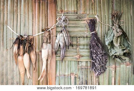drying cereal corn vegetable cotton leaf bush with forest product hanging on bamboo rattan pannel background show rural agriculture life