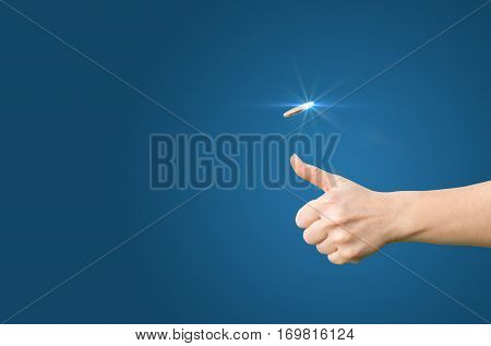 Hand Throws A Coin On A Blue Background For Decision-making