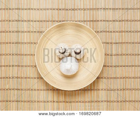 Massage bundles on a plate on bamboo mat. Spa, health, treatment, concept. 