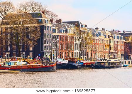 Amsterdam, Netherlands - April 2, 2016: Traditional old buildings, canal and boat in Amsterdam, the Netherlands