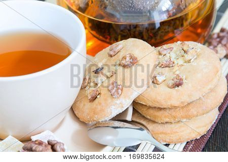 Cup of tea and a few round cookies with nuts for breakfast