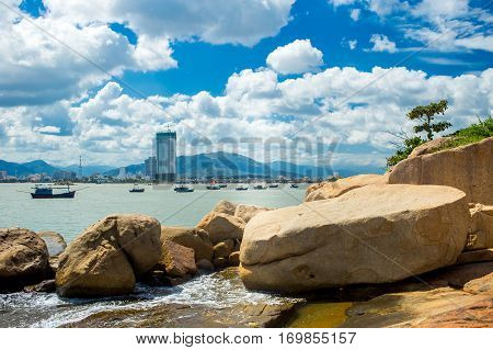Landscapes on Hon Do island in the sea near Nha Trang city, Vietnam. Clouds, sky and orange rocks and small pagoda with hieroglyphs. Vibrant horizontal image