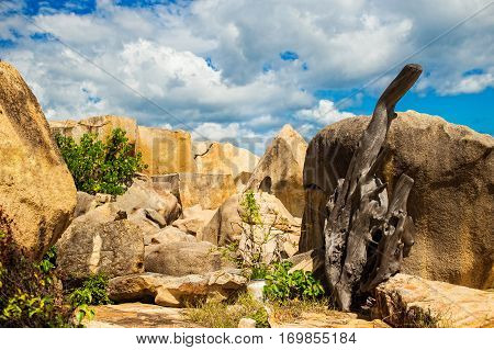 Landscapes on Hon Do island in the sea near Nha Trang city, Vietnam. Clouds, sky, old tree and orange rocks and small pagoda with hieroglyphs. Vibrant horizontal image