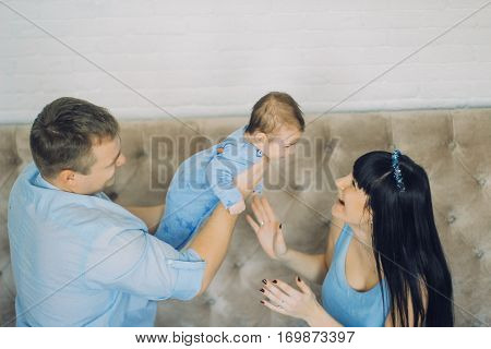 happy family consisting of mom and dad's baby boy. happy family relationships. father holding the baby in his arms. child flies