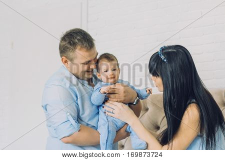 happy family consisting of mom and dad's baby boy. happy family relationships. father holding the baby in his arms. child flies