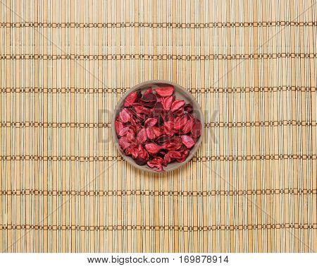 Plate with aroma petals on bamboo mat. Spa, beauty, treatment concept. 