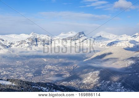 Chain of peaks in Alps above the clouds and villages