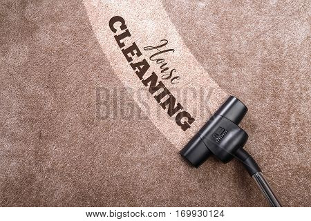 Vacuuming carpet with vacuum cleaner. House cleaning. Housework service. Close up of the head of a sweeper cleaning device.