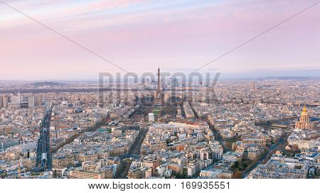 Aerial panoramic view of Paris skyline with Eiffel Tower, Les Invalides and business district of Defense at pink sunset, as seen from Montparnasse Tower, Paris, France