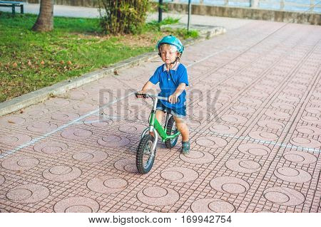 Active Blond Kid Boy Driving Bicycle In The Park Near The Sea. Toddler Child Dreaming And Having Fun