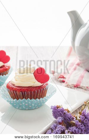 Red velvet heart cupcakes with cream cheese frosting and a red heart for Valentine's Day