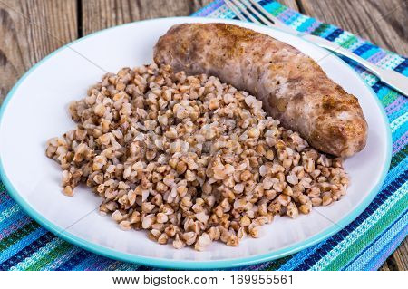 Fried sausage with buckwheat on Plate. Studio Photo