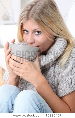 Beautiful woman drinking hot drink in winter