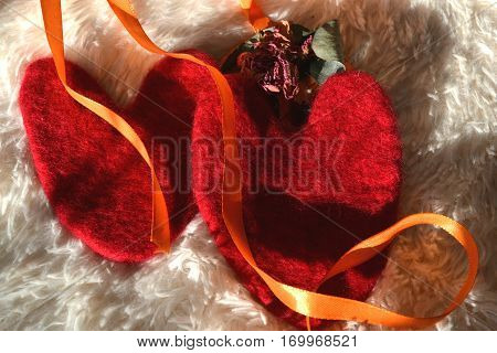 valentines with orange ribbon on a white canvas with a nap