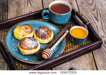 Pancakes with honey on vintage bowl on wooden tray. Studio Photo