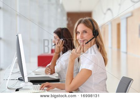 Business folk arbejde foran computeren med hovedtelefoner