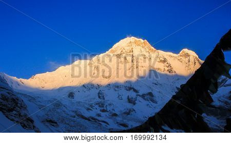 Before sunrise from Annapurna Base Camp (ABC) Trekking on the trail in the mountains. Sport girl with backpack travels in Himalayas. Nepal trek to ABC. Female traveler near Annapurna Base Camp. Snow a