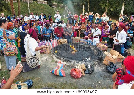 TIKAL, GUATEMALA - DEC 21, 2015: Unidentified Mayan people and tourists surround a fire on December 21, 2015  in Tikal, Guatemala. Traditional Mayan fire ceremony at the 2015 new year celebrations.
