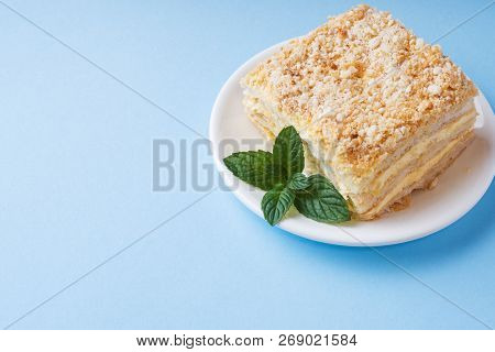 Layer Cake With Cream Napoleon Millefeuille Vanilla Slice With Mint On A Colored Blue Background.