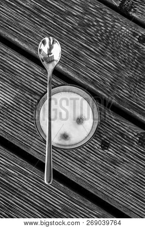 A Latte Machiato From Above Stands On The Terrace With A Silver Spoon That Lies Across The Glass. Th