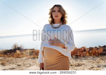 Pregnant Woman Walking Near The River In A Sunny Weather