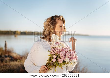Woman Walking With A Bunch Of Flowers Outdoor