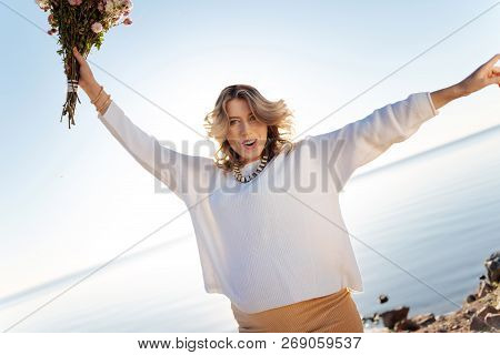 Exited Pregnant Woman Holding A Bunch Of Flowers