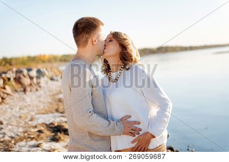 Young Man Romanticly Kissing His Pregnant Wife