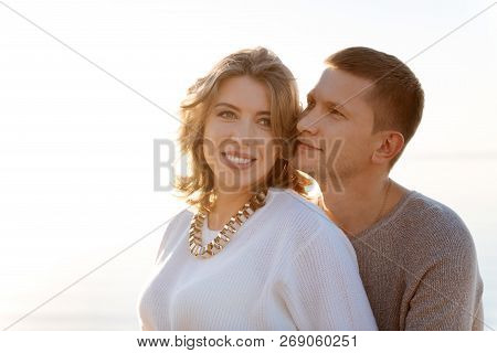 Young Family Romanticly Hugging Each Other Outdoor